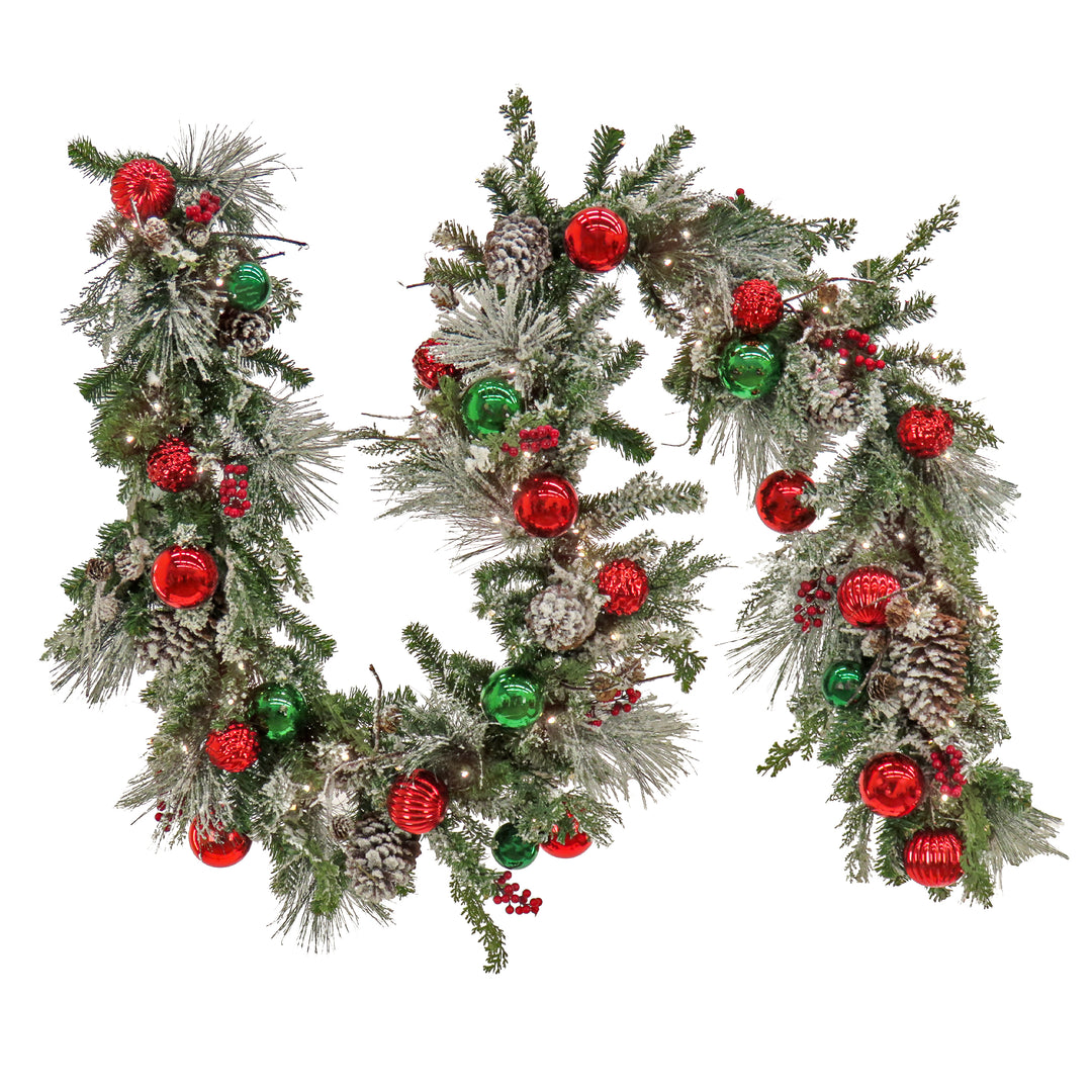 National Tree Company Pre Lit Artificial Garland, General Store, Green, Frosted, Decorated with Red and Green Ball Ornaments, Frosted Pine Cones, Red Berry Clusters, Warm White LED Lights, Battery Powered, Christmas Collection, 9 Feet